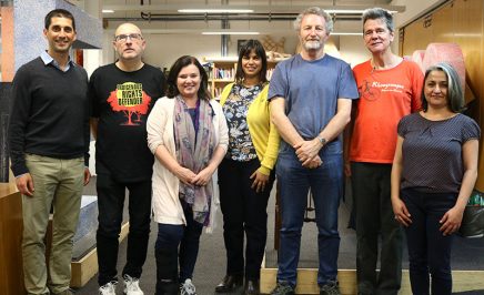 A group of people stand in a line smiling towards the camera. There are four men and three women. They are in the reception area of the Sydney office of Amnesty International Australia