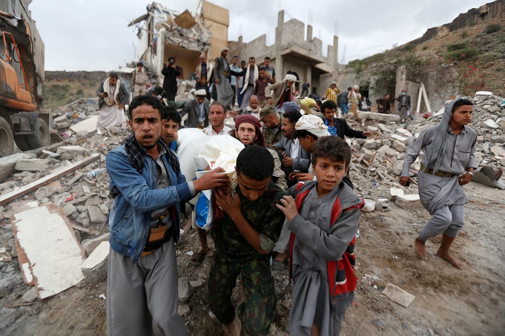 The body of a victim of an airstrike in Yemen is carried out of the rubble