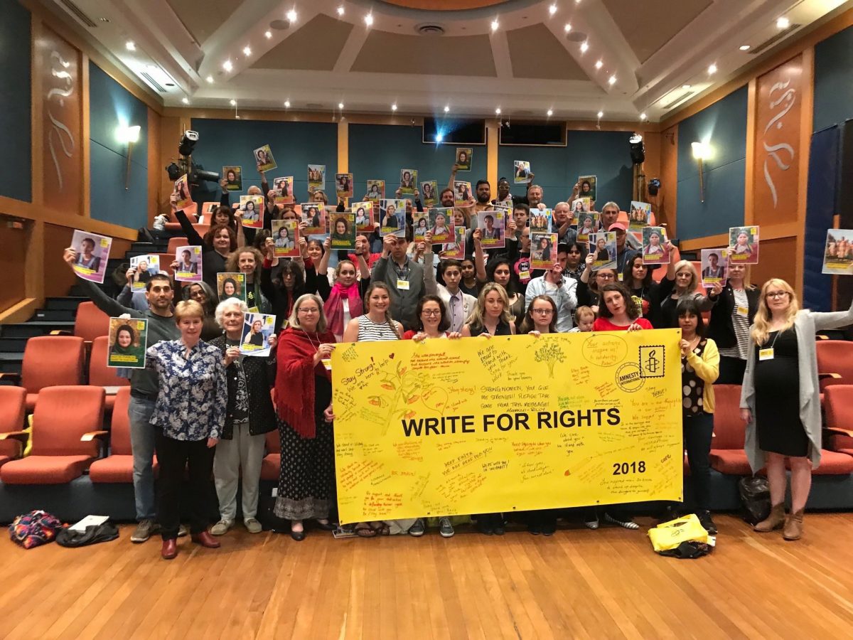 attendees of NAGM 2018 hold up a banner reading 