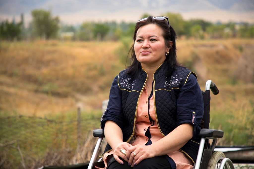 Woman in a wheelchair with countryside behind her