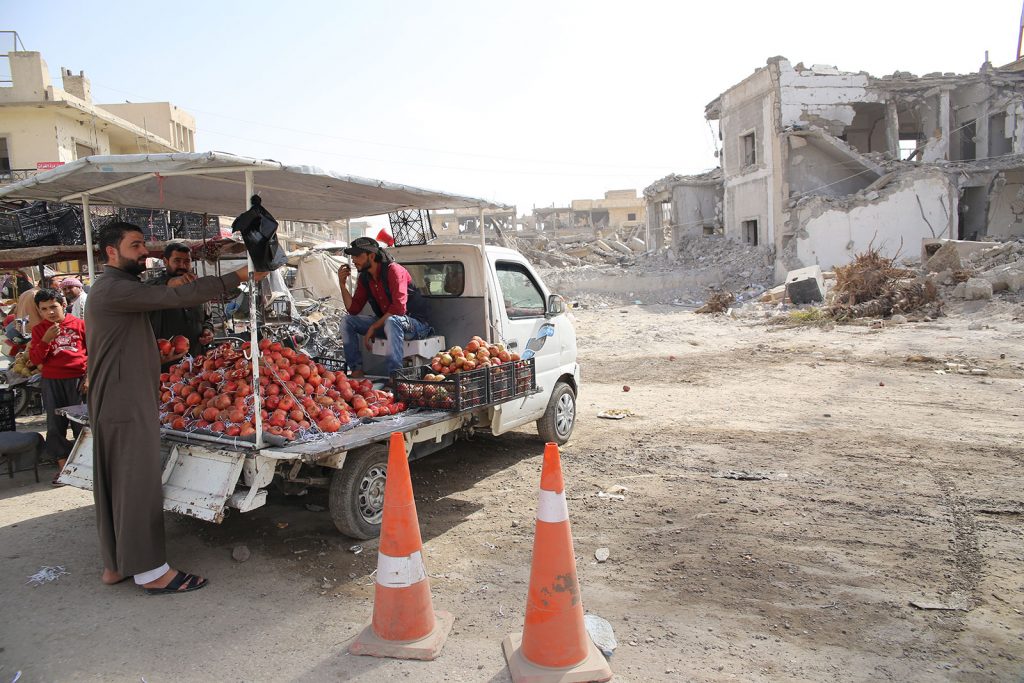 Farmers in Syria unloading vegetables from a flatbed truck.