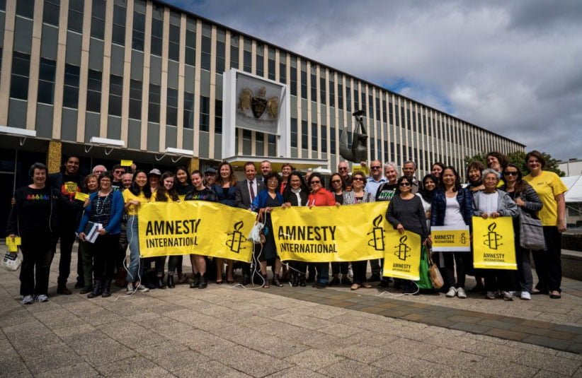 A group of people holding Amnesty banners