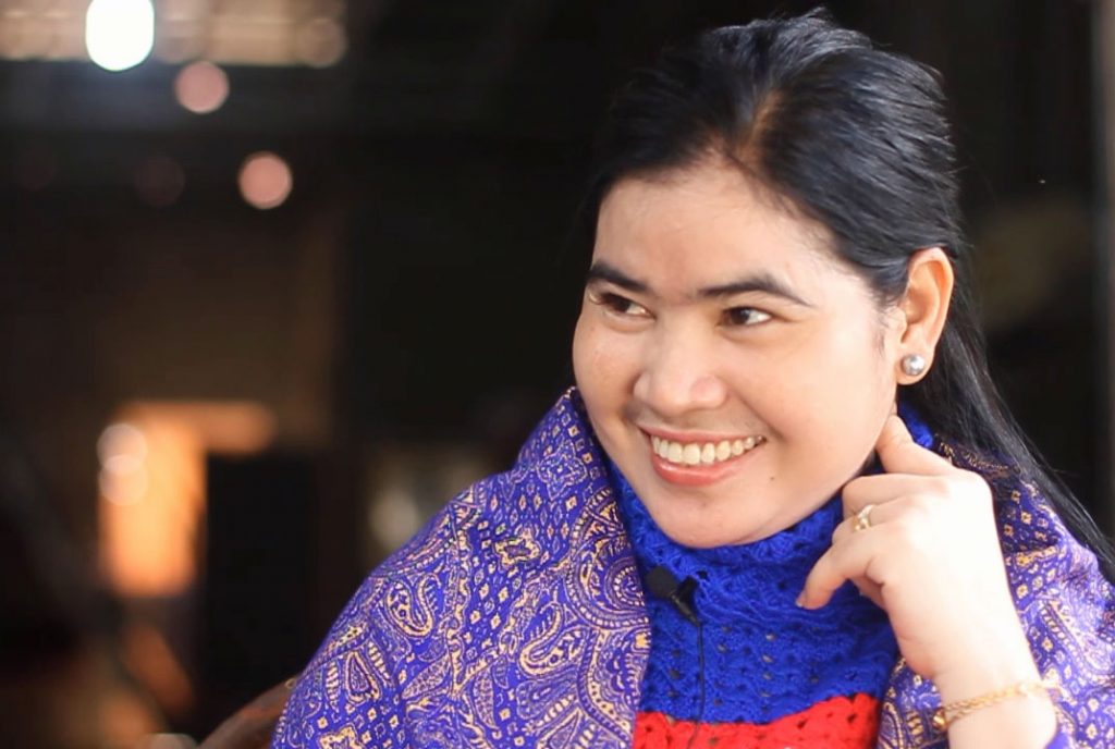Tep Vanny, wearing brightly coloured clothes, smiles at someone off-camera.