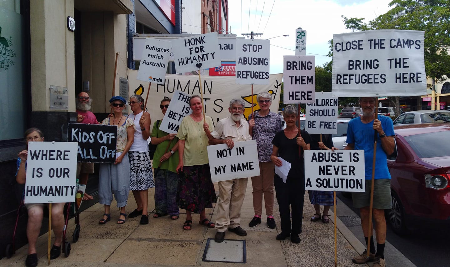 About 20 members of the Lismore Group holding placards standing outside their MP's office calling for the closure of Manus and Nauru