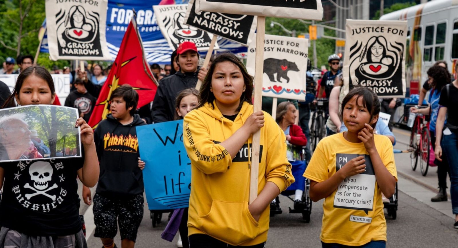 A group of young people holding placards on the street. Grassy Narrows demonstration,Toronto, Canada.