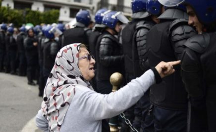 An elderly Algerian woman talks to a member of the security forces cordoning off a protest area during an anti-establishment demonstration in the capital, Algiers
