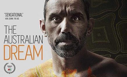 Adam Goodes a mans face with aboriginal art in background