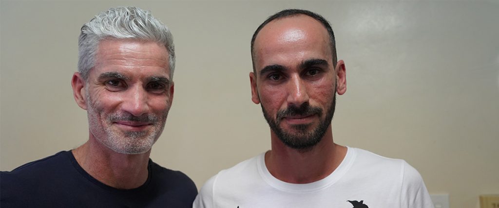 Craig Foster (left) and Moz (right), a young man with dark hair, in a plain room with a beige background.