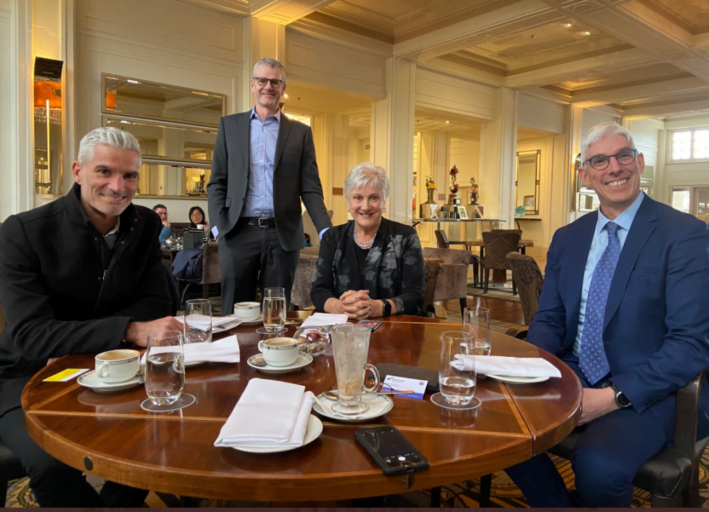 Craig Foster and Dr Graham Thom sit at a table with the New Zealand High Commissioner to Australia