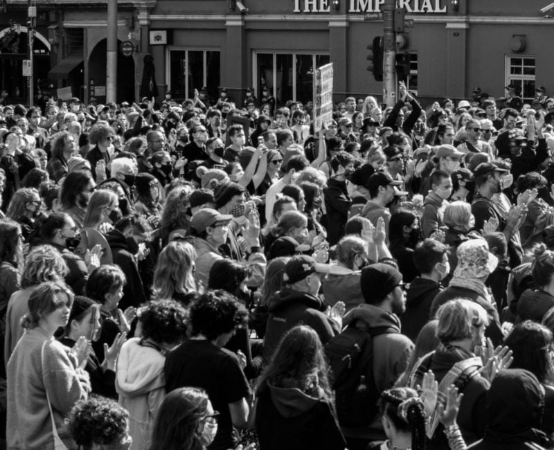 A group of protestors looking and marching onwards at the Black Deaths in Custody Rally in Melbourne, 2021.