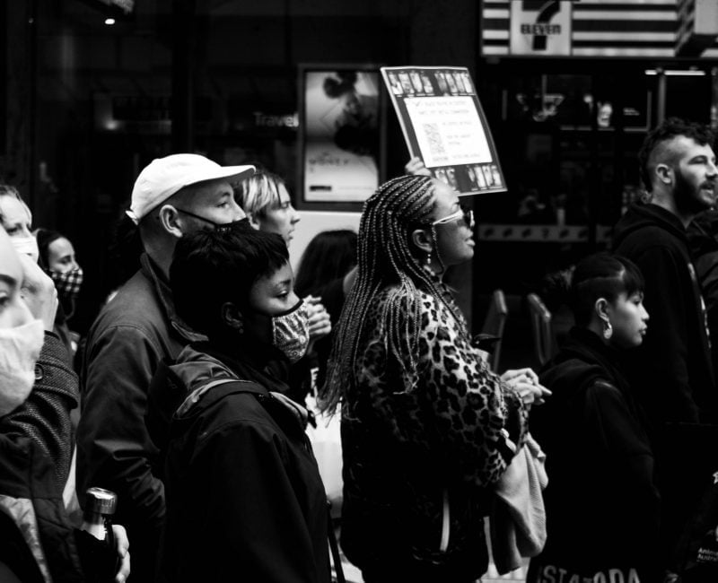 A group of protestors looking and marching onwards at the Black Deaths in Custody Rally in Melbourne, 2021.