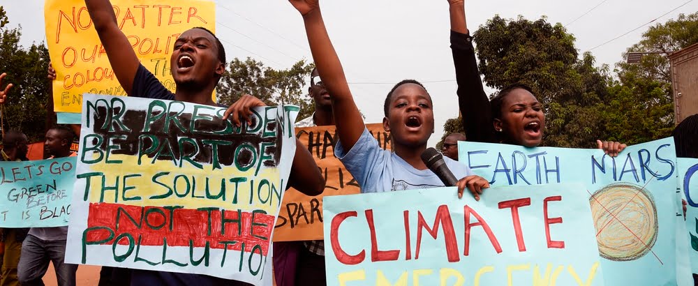 Young people hold up banners as they take part in a march, part of the global Climate Walk 2019, against climate change in Wakiso, on September 20, 2019.