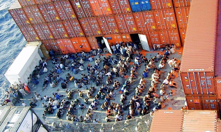 The 433 rescued asylum seekers onboard the Norwegian cargo ship MV Tampa crowded together in between shipping containers awaiting asylum.