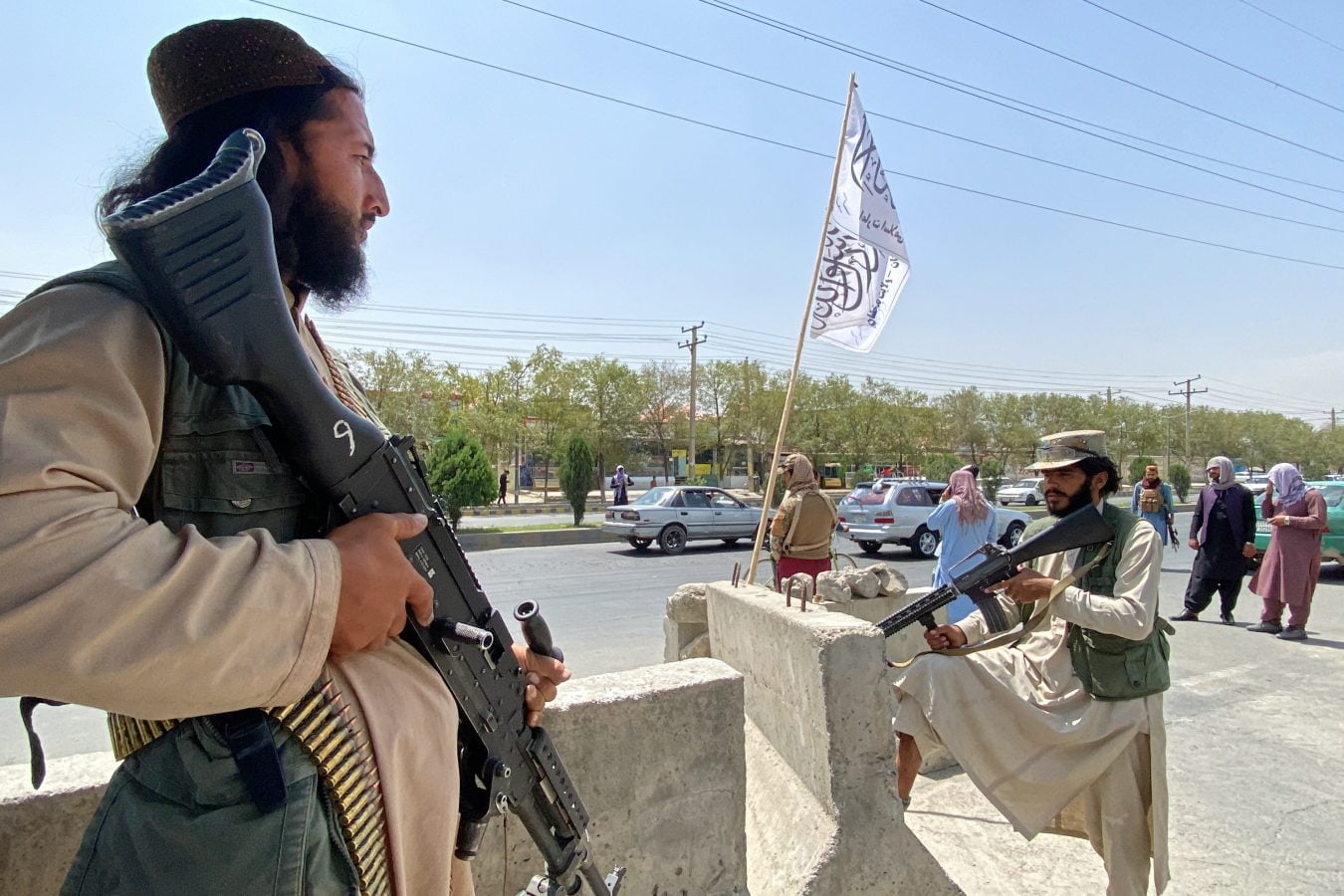 Taliban fighters stand guard at an entrance gate.