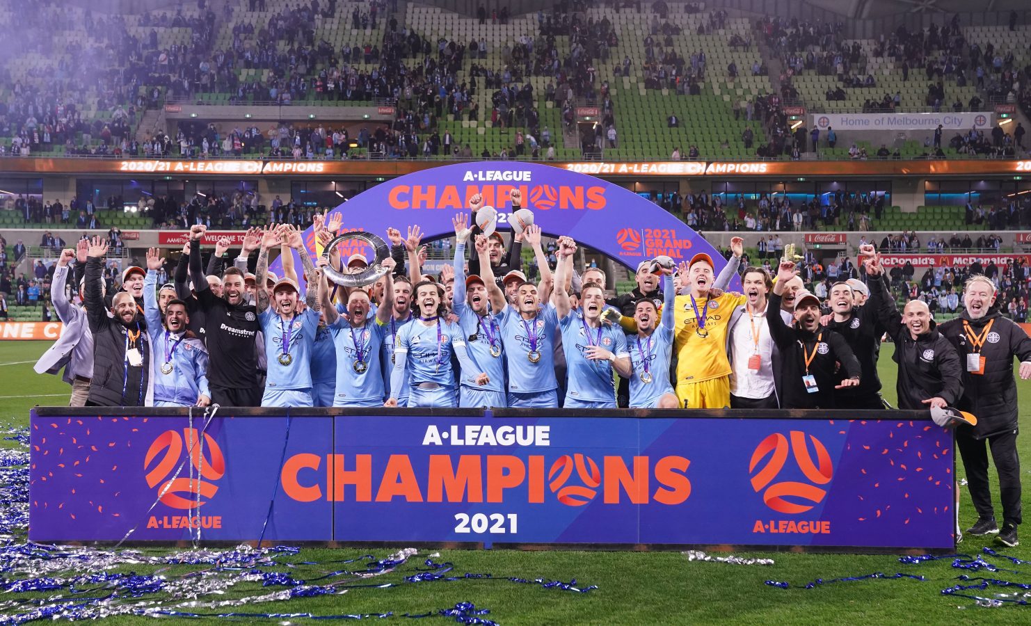 Melbourne City captain, head coach and players celebrate with trophy after winning the A-League Grand Final match between Melbourne City and Sydney FC at AAMI Park in Melbourne, Sunday, June 27, 2021.