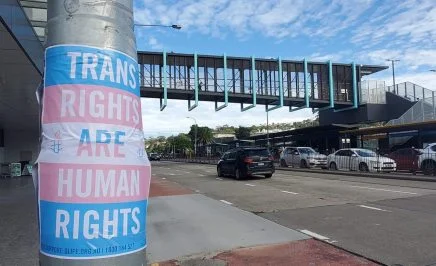 Poster taped to a pole on the street reads 
