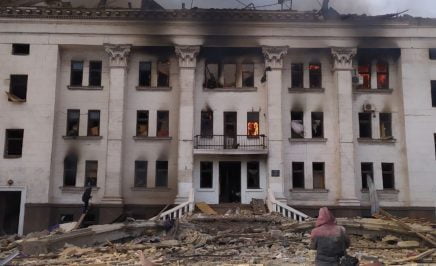 An actor who used to perform at the theatre and a survivor of the attack, stands outside the rear of the Mariupol theatre in Ukraine moments after the explosion.