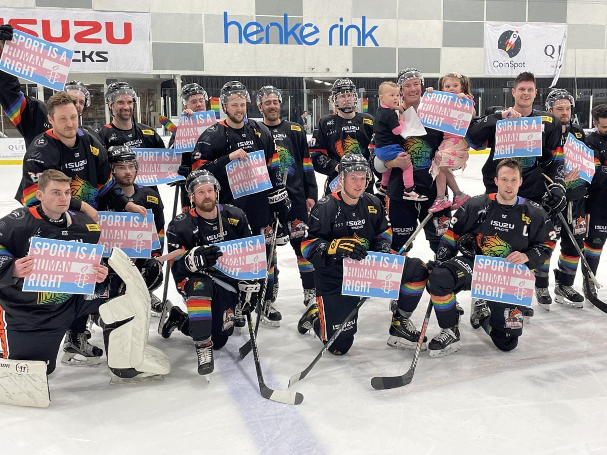 Melbourne Mustangs players holding “sport is a human right” signs, supporting the inclusion of trans and gender diverse people in sport.