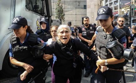 Elderly woman being detailed by female police at demonstration