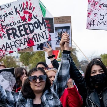 Women taking to the streets in Iran holding signs that say 'They are killing us because we want freedom'