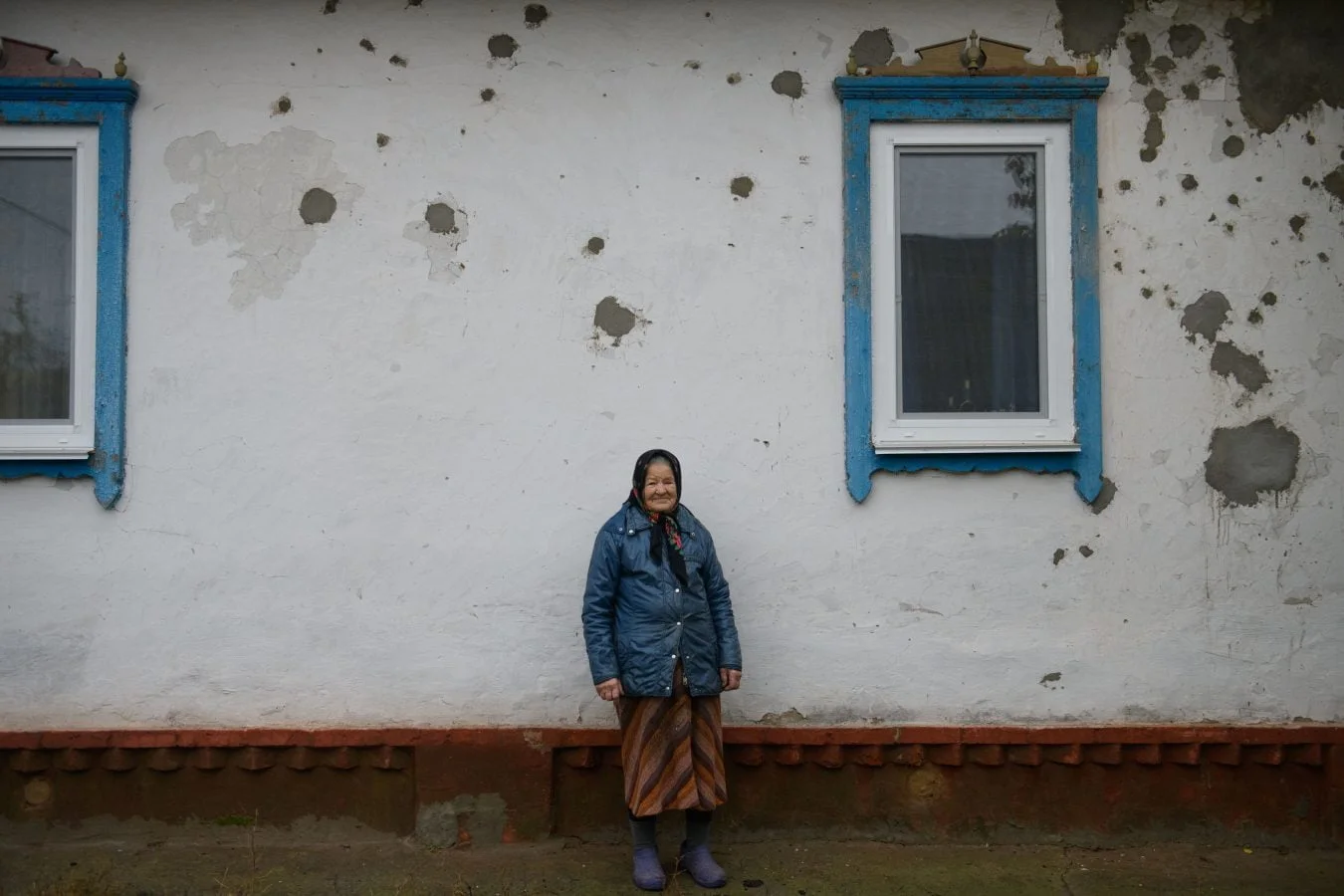 An elderly woman in front of her home which was heavily damaged during attacks in Chernihiv, Ukraine.