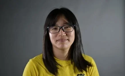 Chow Hang-tung in yellow tshirt on grey background