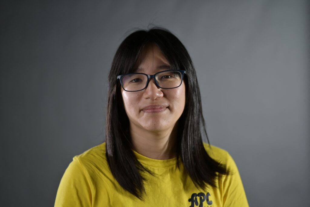 Chow Hang-tung in yellow tshirt on grey background