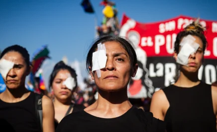 Chilean protesters with eye patches stand in solidarity at a rally