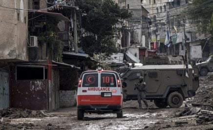An Israeli soldier gestures towards a Palestinian Red Crescent ambulance at the entrance of the Tulkarem refugee camp.