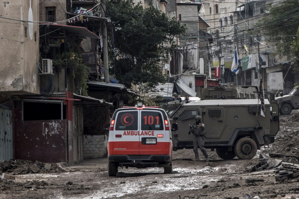 An Israeli soldier gestures towards a Palestinian Red Crescent ambulance at the entrance of the Tulkarem refugee camp.