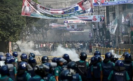TOPSHOT - Police personnel stand guard in front of Bangladesh Nationalist party (BNP) activists during a rally demanding the resignation of Prime Minister Sheikh Hasina and the release of BNP Chairperson Begum Khaleda Zia, in Dhaka on October 28, 2023. Police fired tear gas and rubber bullets at huge crowds of Bangladesh opposition supporters on October 28, to break up a giant protest against the Prime Minister, with one officer killed and scores of people injured in several hours of violent clashes in central Dhaka. (Photo by Munir uz zaman / AFP) (Photo by MUNIR UZ ZAMAN/AFP via Getty Images)