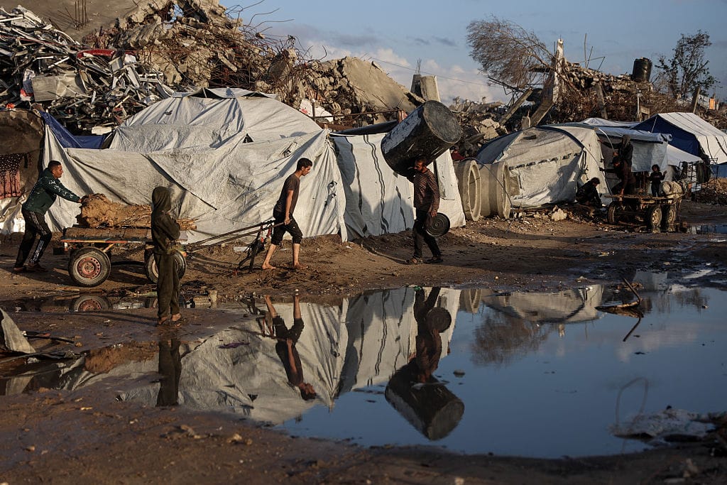 A displaced Palestinian man pulls a cart after heavy rain in Jabalia city, northern Gaza Strip, on November 25, 2025. The Gaza Strip has been largely reduced to rubble after two years of fighting, sparked by Hamas's attack on Israel on October 7, 2023, which resulted in the deaths of 1,221 people. Israel's retaliatory assault on Gaza has killed at least 69,733 people, according to figures from the health ministry that the UN considers reliable.