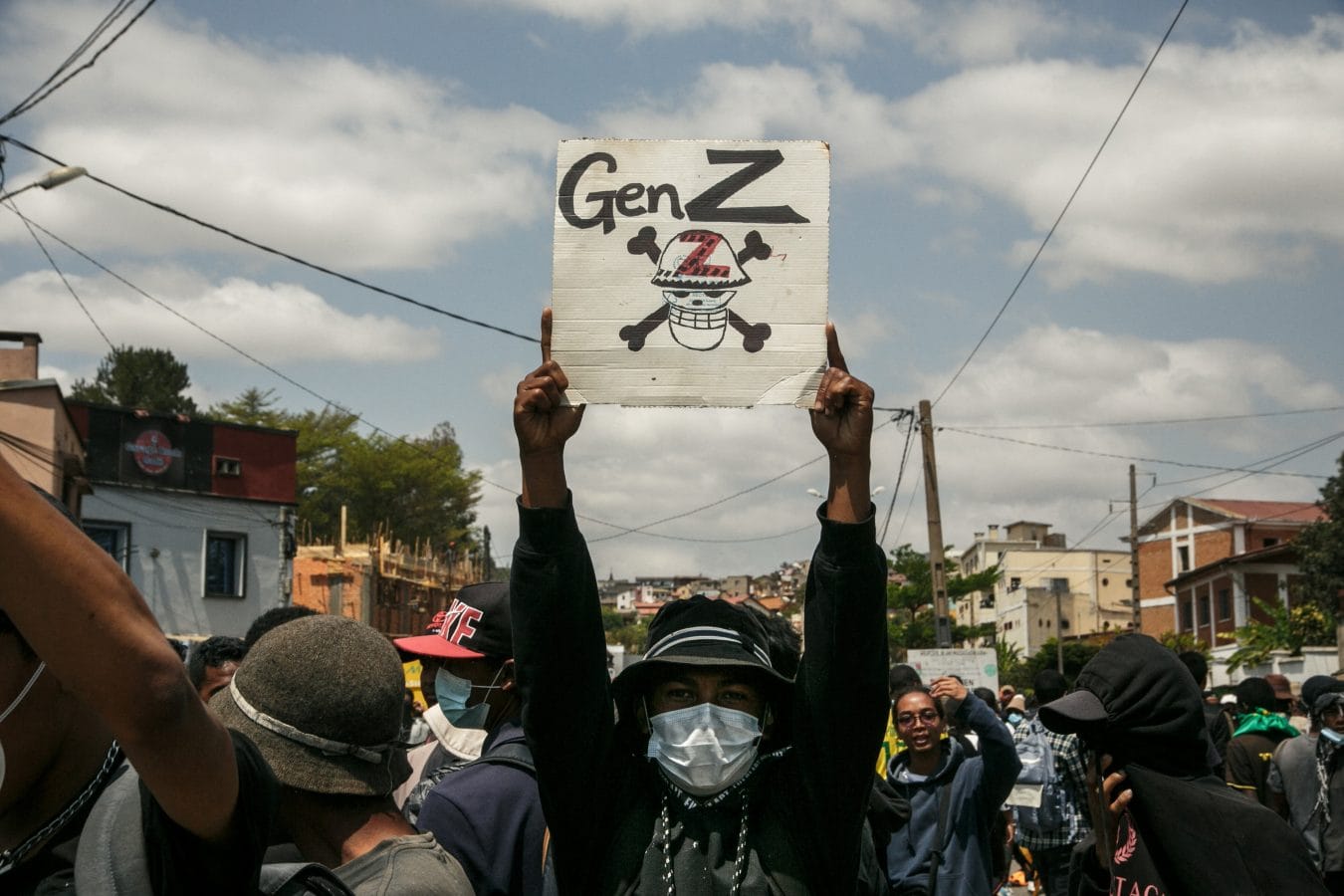 TOPSHOT - A protester holds a placard during a demonstration against repeated water and electricity outages in Antananarivo on September 27, 2025. Hundreds of mostly young protesters faced off against security forces in Madagascar's capital on September 27, 2025 days after an anti-government demonstration erupted into clashes and looting. Police used rubber bullets and teargas to disperse crowds at Thursday's protest, which was called to condemn persistent water and power cuts in the impoverished nation but descended into violence as stores were looted and buildings and cars set alight. (Photo by RIJASOLO / AFP) (Photo by RIJASOLO/AFP via Getty Images)
