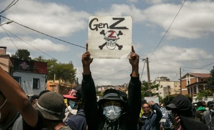 TOPSHOT - A protester holds a placard during a demonstration against repeated water and electricity outages in Antananarivo on September 27, 2025. Hundreds of mostly young protesters faced off against security forces in Madagascar's capital on September 27, 2025 days after an anti-government demonstration erupted into clashes and looting. Police used rubber bullets and teargas to disperse crowds at Thursday's protest, which was called to condemn persistent water and power cuts in the impoverished nation but descended into violence as stores were looted and buildings and cars set alight. (Photo by RIJASOLO / AFP) (Photo by RIJASOLO/AFP via Getty Images)